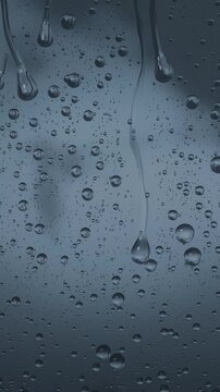 Vertical video: Showing window glass pane forming sliding long drops and vertical streaks from rain