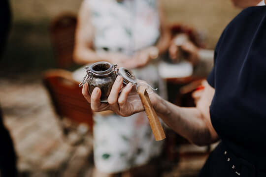 Guest holding a small jar of soil at a wedding ceremony