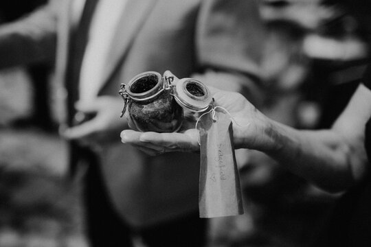 Hand holding small soil jar with tag in black and white