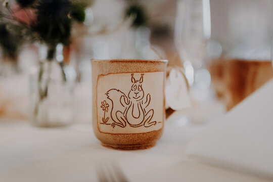 Handmade ceramic mug with squirrel drawing and flowers