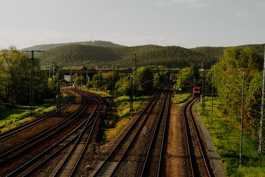Railway tracks curving through green hills at sunset