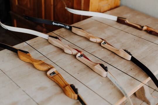 Wooden recurve bows lying in a row on a table