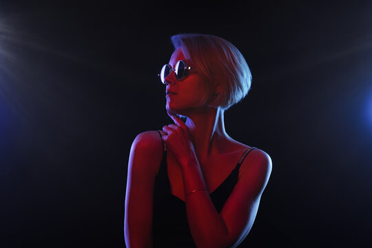 Portrait of fashion real young girl in red neon light in the studio