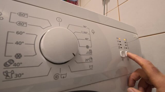 Finger Pressing Washing Machine Control Panel Buttons