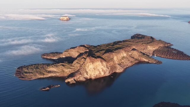 Volcanic island of Nea Kameni in Santorini Greece surrounded by calm blue water