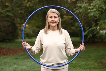 Senior woman with hula hoop in park © New Africa