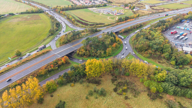 Traffic flow on Old Craighall road junction surrounded by autumn fields and green countryside in East Lothian
