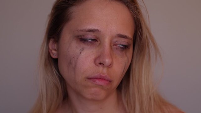 Young blonde woman with traces of tears and smeared mascara, showing no emotions after crying. Portrait of burnout, emotional emptiness, silence and complete exhaustion