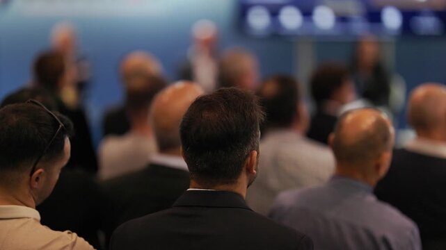 Business audience listening to presentation at corporate conference
