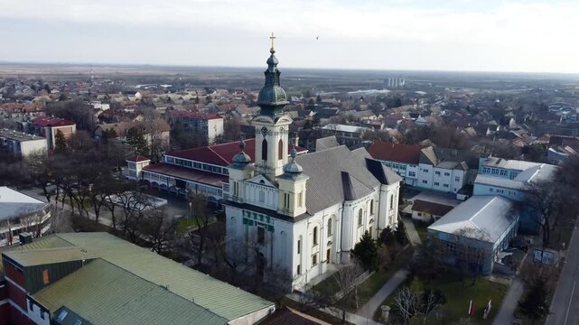 Aerial view of the Catholic church with flying pigeons in Kula, Vojvodina, Serbia. Drone landscape. g.