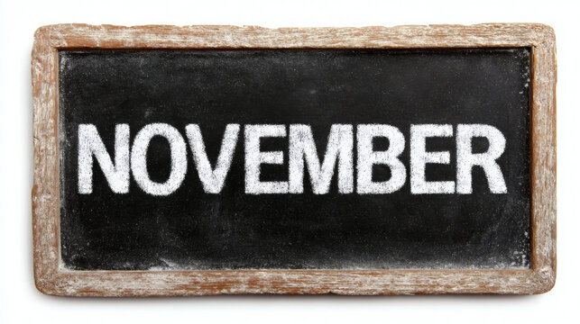 "NOVEMBER" written in white chalk on a small slate chalkboard