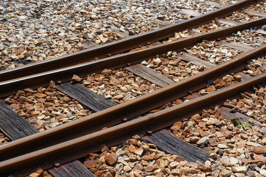 Railway Rails and Weathered Wooden Sleepers on Stone Ballast