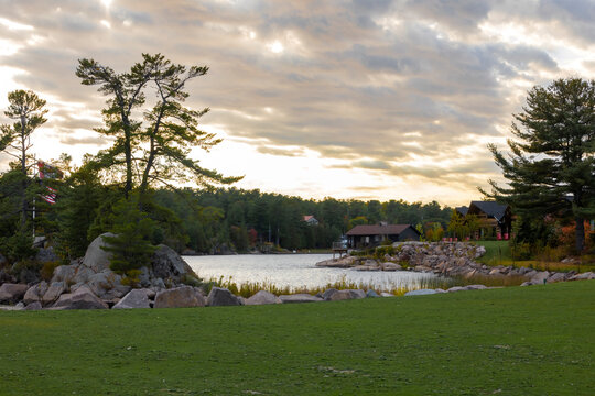 Tranquil sunset view along Killarney Channel, Ontario with lush trees and rocky shoreline.