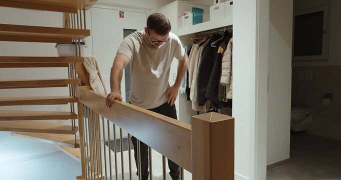 Dizzy man holding a railing for support at home