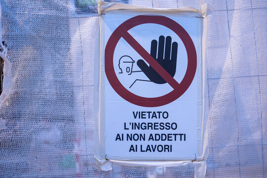 Italian construction site warning sign prohibiting entry to unauthorized persons on white netting in Rome, Italy