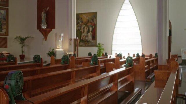 Blurred church interior with shallow bokeh and wooden pews in soft natural light; background backplate copyspace calm.