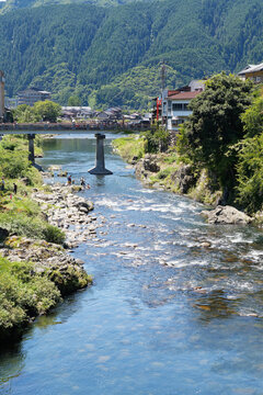 River and bridge in a mountain town with forested slopes