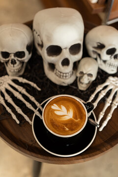 Halloween celebrated coffee,Close up of Hot coffee latte with latte art milk foam in cup mug with decor in a coffee a theme of halloween on wood desk Halloween holiday background.