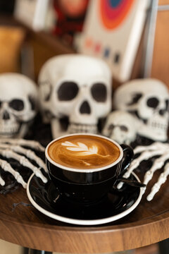 Halloween celebrated coffee,Close up of Hot coffee latte with latte art milk foam in cup mug with decor in a coffee a theme of halloween on wood desk Halloween holiday background.