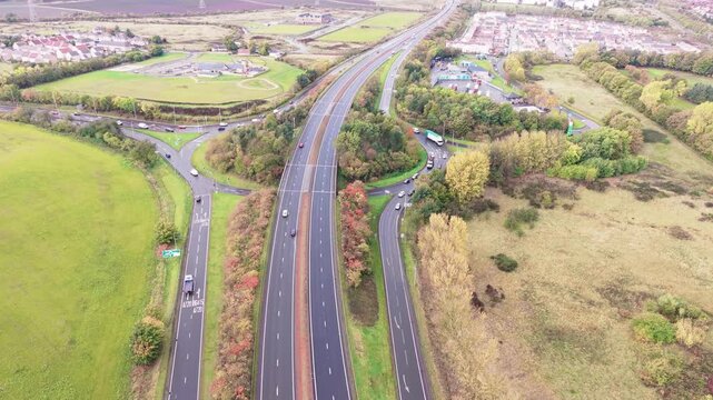 Aerial view of drone flying forward over Old Craighall junction on A720 City Bypass and A1 road near Edinburgh