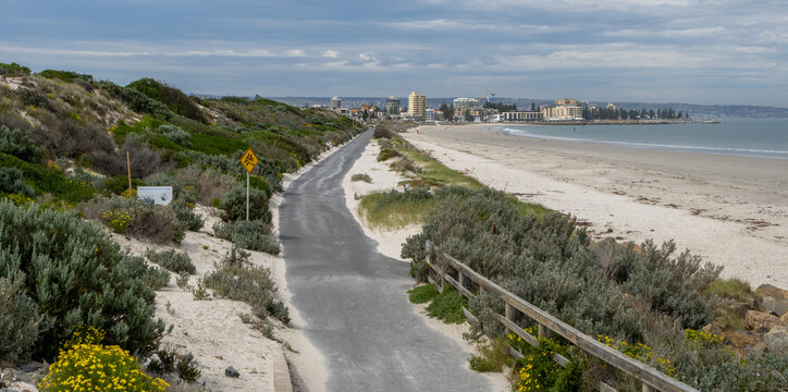 West Beach coastal path for walking and cycling, overlooking the sandy coastline and skyline of Glenelg North in Adelaide, South Australia. Liveable city and outdoor recreation concepts