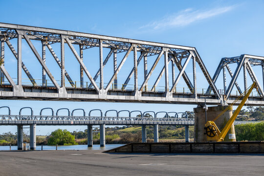 The historic parallel steel truss bridges crossing the wide Murray River at Murray Bridge, South Australia. Engineering infrastructure, riverfront industrial and maritime Heritage