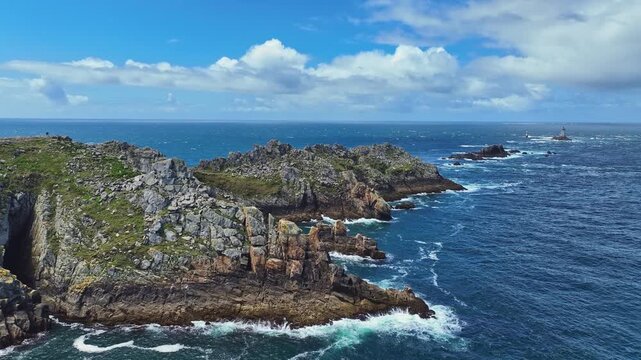 Aerial view of the Pointe du Raz headland on the stormy Breton coast, at whose edges the ocean spray breaks white, on the horizon the historic lighthouse Phare de la Vieille, Plogoff, Cap Sizun, Fini