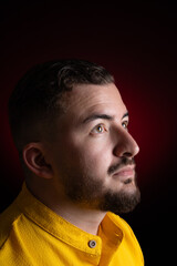 Side profile portrait of thoughtful man wearing yellow shirt in studio © FabianR
