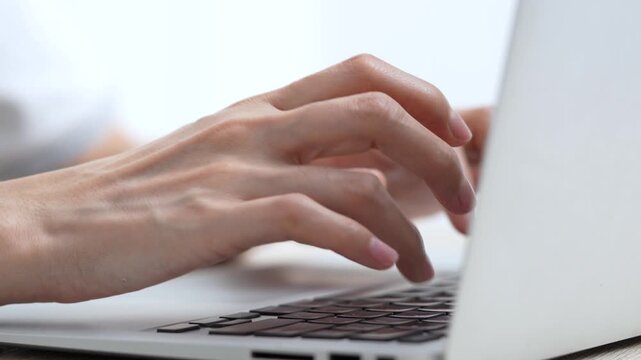 close up human fingers typing on laptop computer keyboard, representing remote work to type report or document, online communication, freelancing, digital business tasks. 