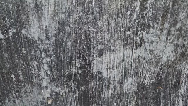 Close up texture of dark weathered wall with white brush strokes
