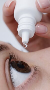 Person applying medicinal eye drops into for treatment or dryness relief with self care medicine ophthalmology prescription hydration wellness