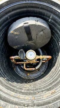 Water meter and pipe fittings inside a utility pit