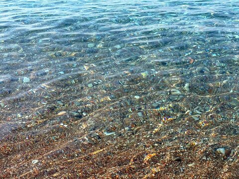 Crystal-clear sea water with pebbles at the bottom 