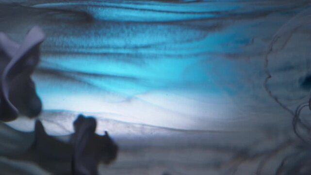 Vertical video. Paint background. Liquid splash. Defocused blue yellow green colorful water acrylic swirling drip spilling on abstraction.