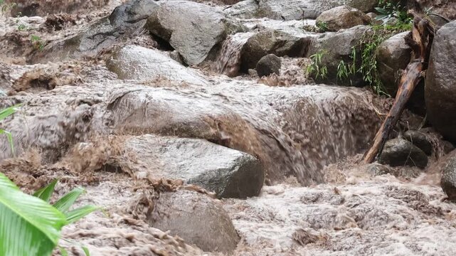 Waterfall Stream Rushing Over Granite Boulder and Wet Stone Through Tropical Forest, Muddy Water Flowing Across Rocky Stream with Lush Green Foliage, Natural Wilderness Scenery and Peaceful Outdoor