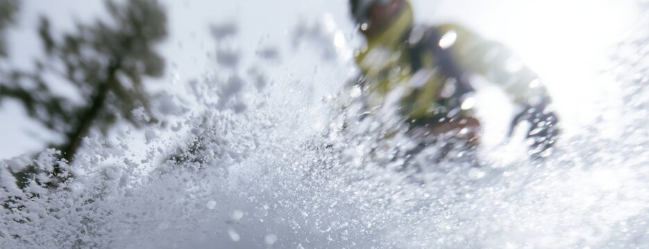 Snowboarder carving through fresh powder snow in a mountain landscape  
