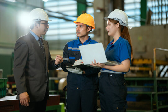 Two Heavy Industry Engineers Stand in Pipe Manufacturing Factory, Use Digital Tablet Computer, Have Discussion. Design and Construction of Large Oil, Electrical control cabinet.