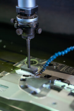 Drill press drilling steel plate in industrial factory