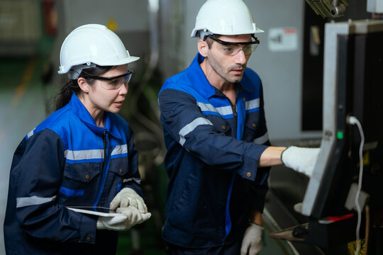 Two Electrical Engineer team working front control panel, Engineer training job with control panel in service room.