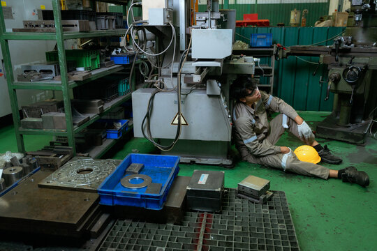 Engineer or Factory worker feeling tired from hard work in a factory, weak, hopeless, burned out, Fired Unemployed Feeling Stressed.