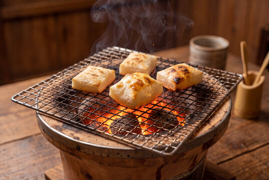 雪の庭を望む縁側で七輪の炭火に焼かれる角餅、鏡開きやお正月を感じる冬の和の情景