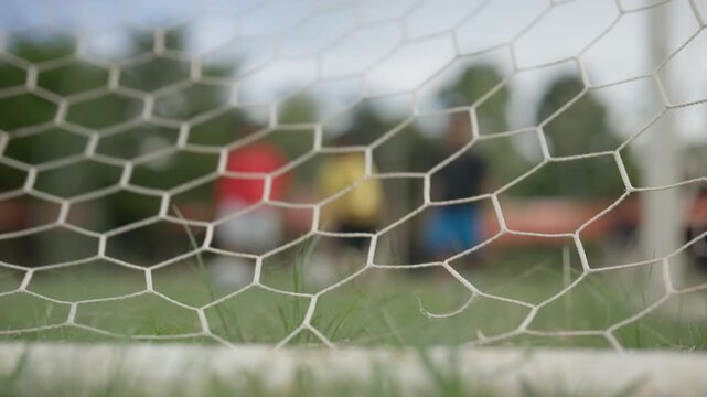 Close Up of Soccer Goal Net with Blurred Football Players in Background
