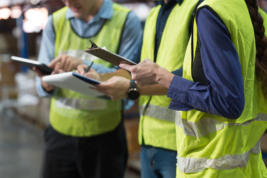 Close up of hands warehouse worker collaborating on logistics management and inventory operations in distribution center