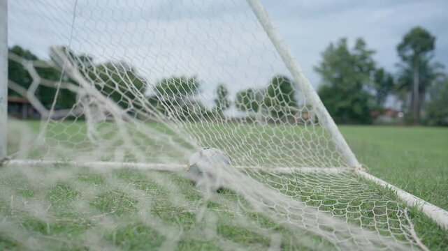 Close Up of White Soccer Goal Net on Green Grass Football Field Outdoors