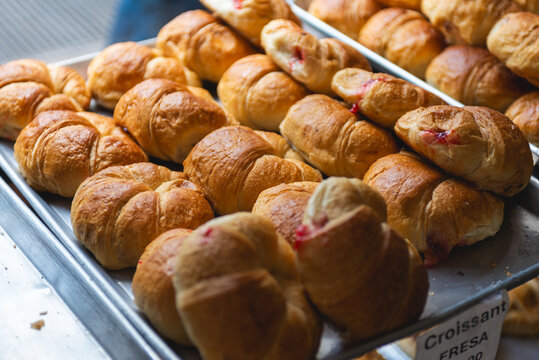 Strawberry Jam Filled Croissants on an Aluminum Tray in a Bakery