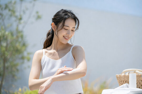 屋外でクリームを腕に塗る女性