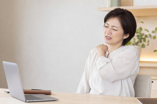 自宅で肩の痛みに悩む中年女性