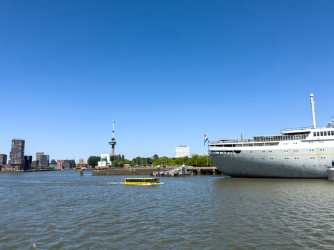 Yellow amphibious bus beside SS Rotterdam in Maashaven harbor in Rotterdam, Netherlands