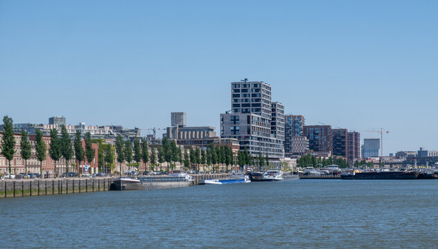 Modern apartment towers above moored barges along the Nieuwe Maas in Rotterdam, Netherlands