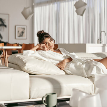 Relaxed Young Woman Lounging on Sofa at Home
